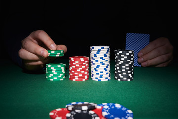 Poker chips on table with hands and cards
