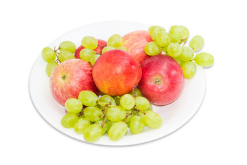 Several apples, nectarines and grape on a white dish