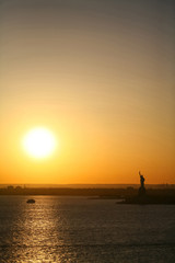 Naklejka na ściany i meble Statue of Liberty and sunset