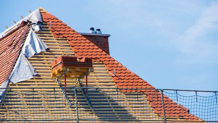 Dachdecker mit Baukran im Hintergrund