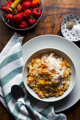 risotto with pumpkin on a wooden table texture. and red chili pe