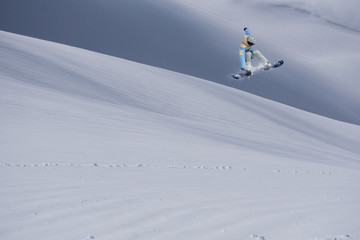 Flying snowboarder on mountains