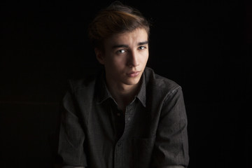 portrait of a young handsome man on black background