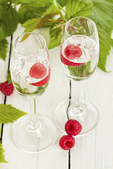 Zwei Gläser Himbeergeist dekoriert mit Früchten und Blättern