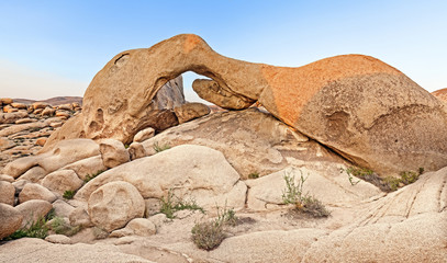 Sunset over arch in Joshua Tree National Park, California, USA.