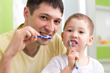 child and his father brushing teeth in bathroom