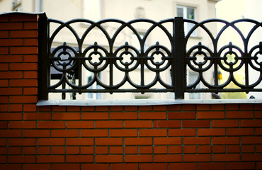 Black wrought iron and brick fence