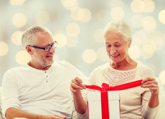 happy senior couple with gift box at home