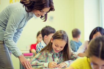 group of school kids writing test in classroom