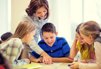 group of school kids writing test in classroom