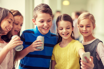 group of school kids with smartphone and soda cans