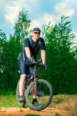 Fototapeta na wymiar portrait of a happy man athlete on a bike