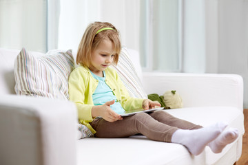 Obraz na płótnie Canvas little girl with tablet computer at home