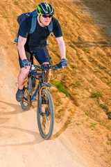 Obraz na płótnie Canvas active man on a bicycle wearing a helmet on a mountain road
