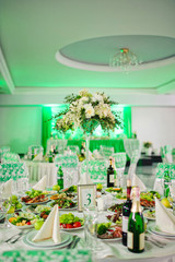 Table with flowers and a lot of food in the restaurant is ready for event or wedding celebration in green color