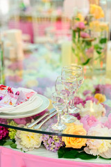 Table set for an elegant dinner / Glass goblets on the prepared table with flowers for celebretion in the luxury restaurant