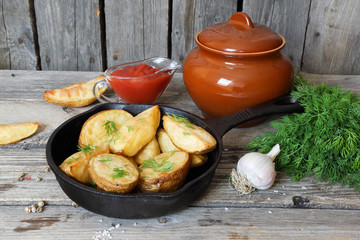 Baked potatoes with dill in village in a cast iron frying pan