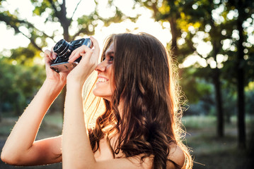 young caucasian female with vintage camera in park