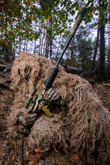 Sniper reload his rifle in forest/Camouflaged sniper in forest reload his rifle with scope
