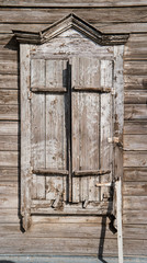 Traditional russian wooden house window with locked shatters in Astrakhan, Russia