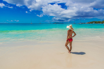 Fototapeta na wymiar Girl with sunhat at Paradise beach 