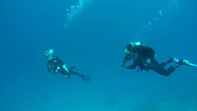 Divers man and a woman floating in the water column, Indian Ocean, Maldives
