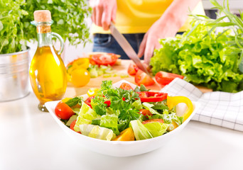 Female hands preparing vegetable salad in the kitchen