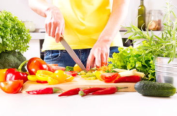 Female hands preparing vegetable salad in the kitchen