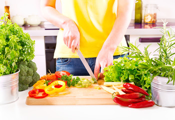 Female hands preparing vegetable salad in the kitchen