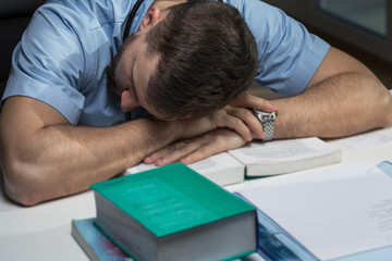 Tired doctor sleeping on desk