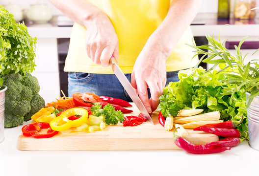 Female hands preparing vegetable salad in the kitchen