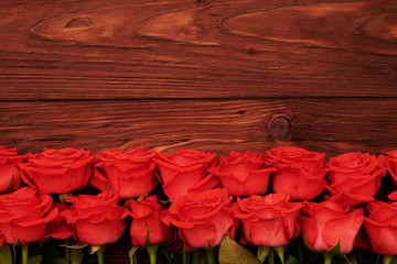 Fototapeta na wymiar fresh red roses with empty wooden copyspace