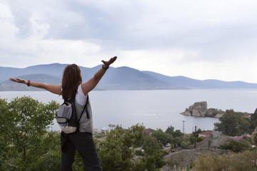Healthy and happy young woman greets the mountain and sea