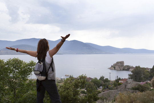 Healthy and happy young woman greets the mountain and sea