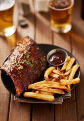 barbecue ribs with french fries and sauce on plate