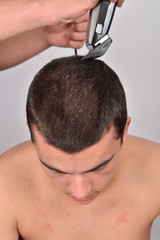 Close up portrait of young handsome man cutting his hair