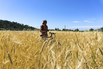 Cyclist man is resting ia gleanings field