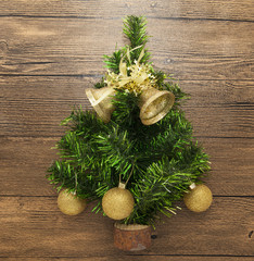 Postcard with a Christmas tree ,Christmas balls, bells, and star on wooden background