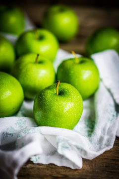 Bright green apples on wooden background