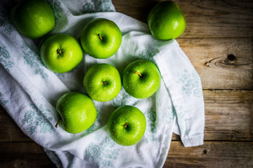 Bright green apples on wooden background