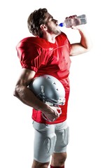Thirsty American football player in red jersey drinking water  © WavebreakmediaMicro