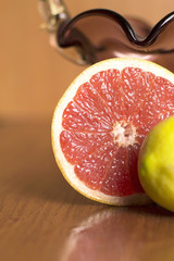 half a grapefruit lying on the table beside the vase