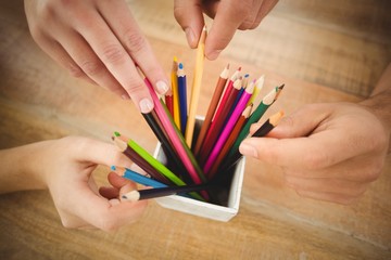 Cropped hands taking color pencils 