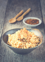 Noodle in ceramic bowl with dried fish on wooden background - Vi