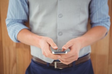 Mid section of businessman using mobile phone