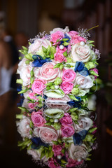 Beautiful colorful wedding bouquet with bride and groom in the b