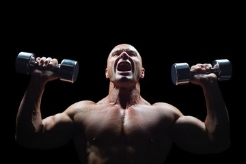 Fototapeta na wymiar Aggressive bodybuilder lifting bumbbells