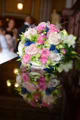 Beautiful colorful wedding bouquet with bride and groom in the b