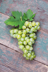 Green and purple round grapes on old wooden table