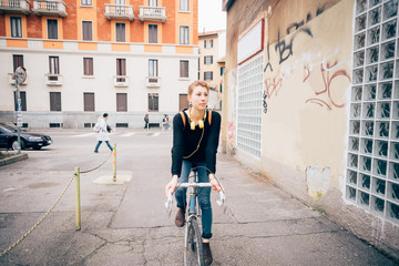Fototapeta premium young beautiful hipster sporty blonde woman riding her bike in t